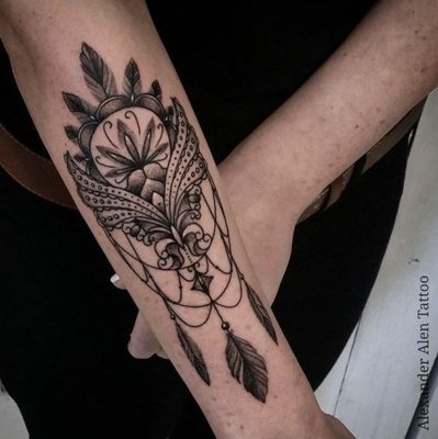 Tatouage plume avec une sorte de mandala sur l'avant bras